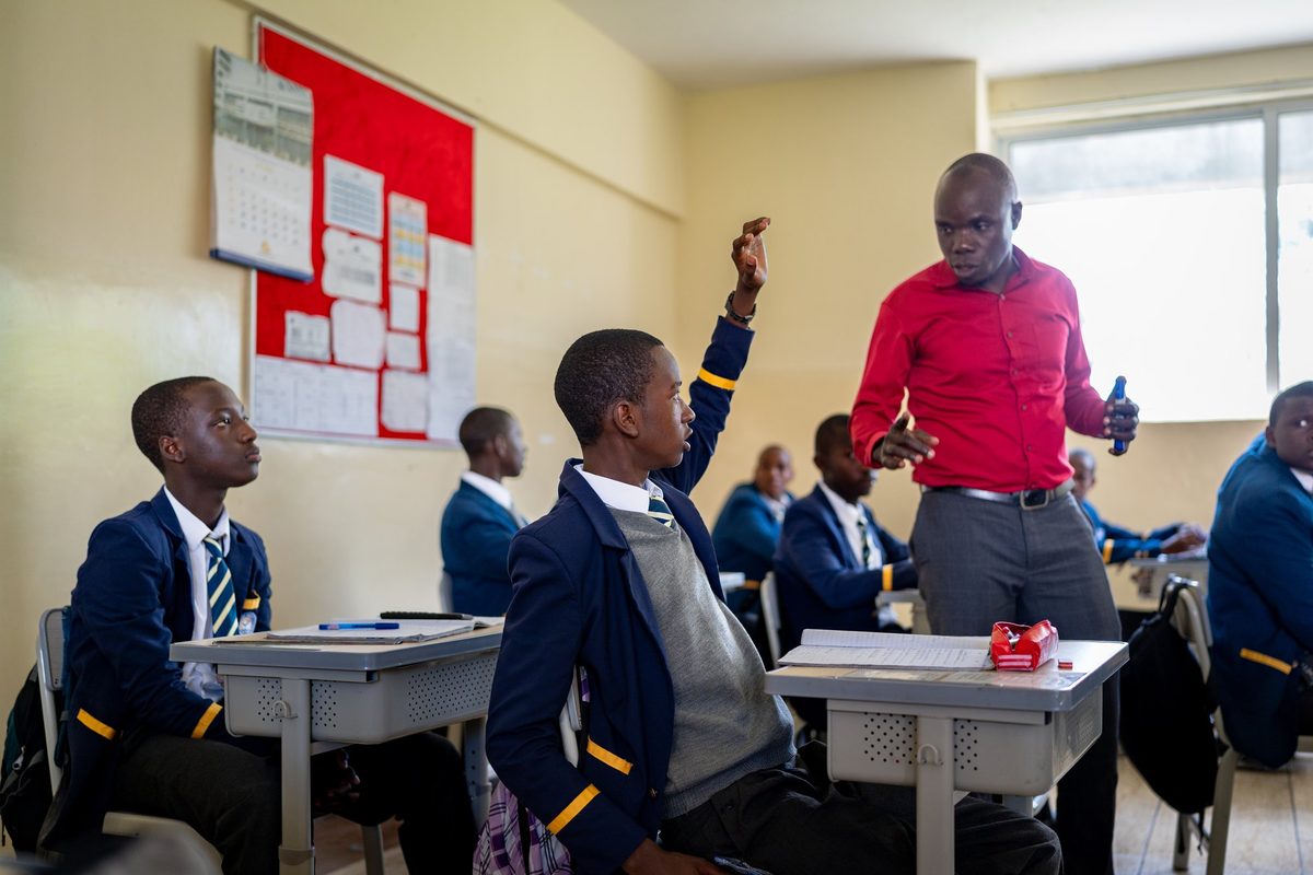 A boy raising his hand in class